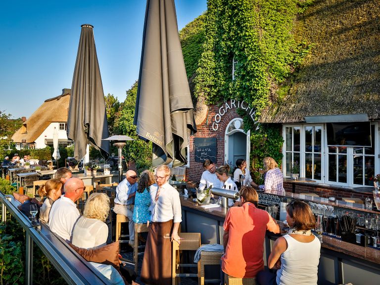 Gäste in einem Restaurant in Kampen auf Sylt genießen regionale Küche und entspannte Stunden.