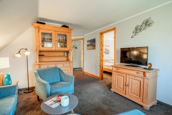 Im Wohnzimmer steht eine Kommode mit TV sowie ein Buffetschrank. 