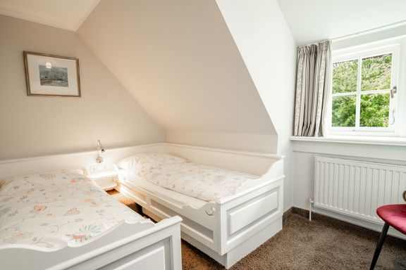 im zweiten Schlafzimmer stehen zwei Einzelbetten und dazwischen steht ein Nachttisch