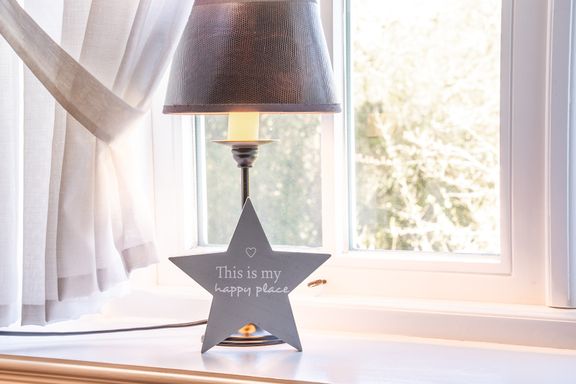 Detailaufnahme von der Lampe auf dem Fensterbrett und Dekostern mit Spruch "this is my happy place"