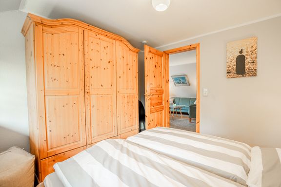 Im Schlafzimmer mit Doppelbett steht am Fußende ein Kleiderschrank